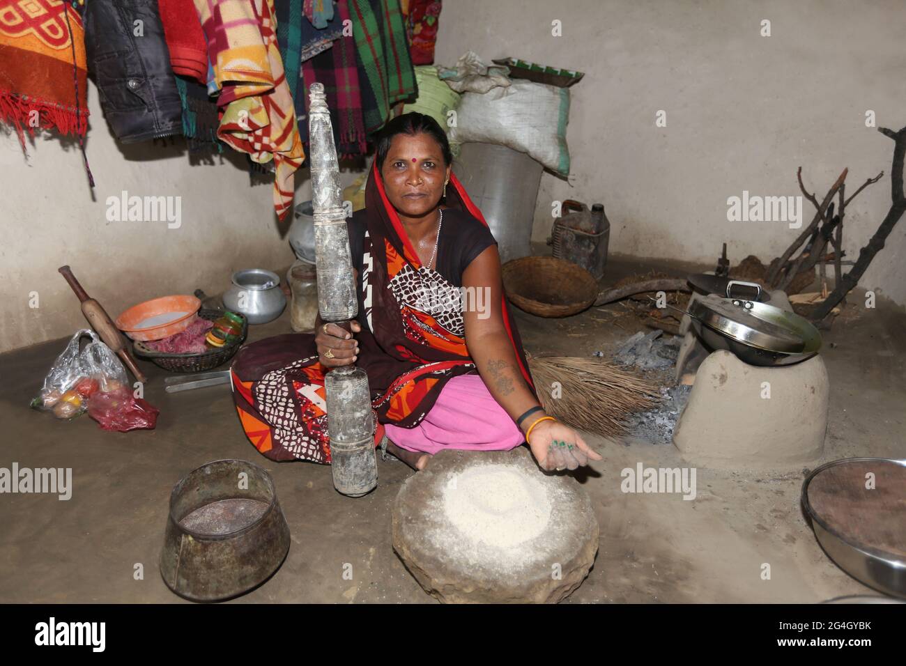 TRIBÙ KOL. Donna che batte grano in mortaio tradizionale e macinacaffè pestello. Bhanpur Villaggio di Huzur Tehsil a Rewa Dist, Madhya Pradesh, India Foto Stock