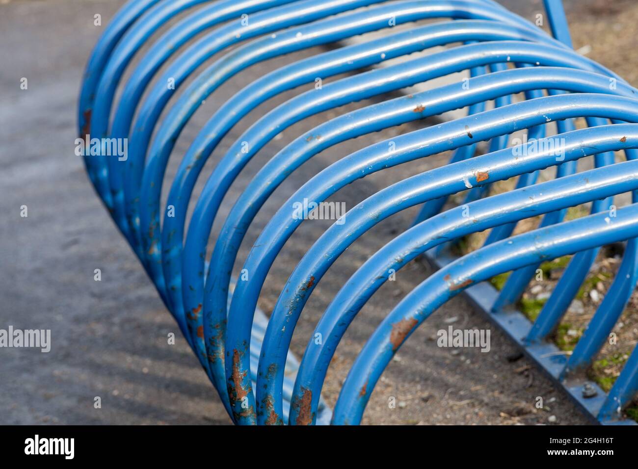 Parcheggio per biciclette in tubi di acciaio blu curvi, fondo astratto di trasporto urbano Foto Stock