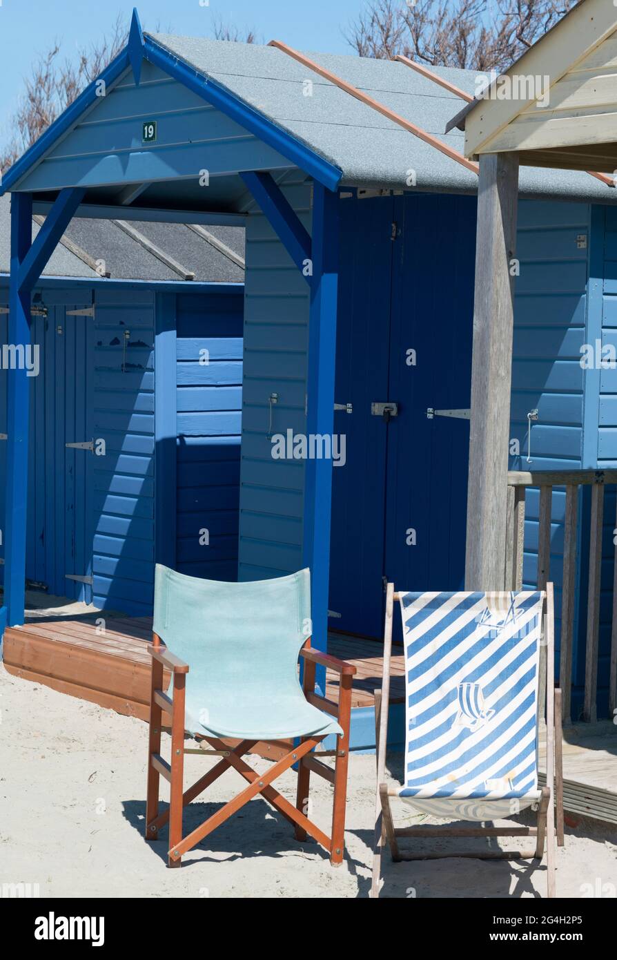 Colorate baite blu rustiche con sedie a sdraio sulla costa sud Bandiera Blu, spiaggia di sabbia bianca a West Wittering, Chichester, West Sussex, Inghilterra, Regno Unito Foto Stock
