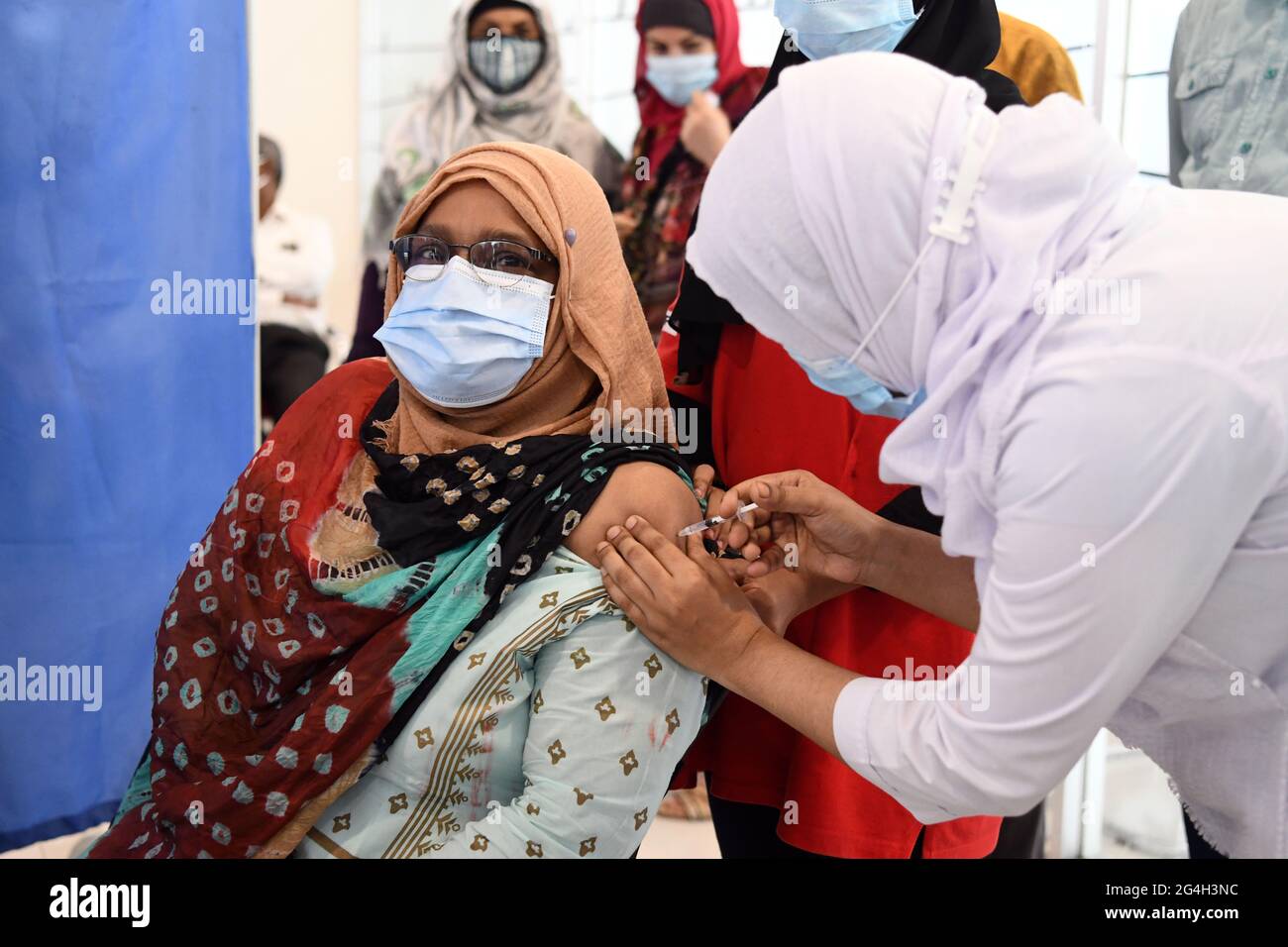 Dhaka, Bangladesh. 21 Giugno 2021. Una donna anziana è stata vaccinata per Covid -19 durante una vaccinazione di massa al Bangabandhu Sheikh Mujib Medical University Hospital di Dhaka. L'inoculazione a livello nazionale contro il coronavirus è iniziata con la speranza di stimolare un rapido recupero dalla pandemia COVID-19. La vaccinazione contro il coronavirus Pfizer-Biotech è iniziata in Bangladesh. Credit: SOPA Images Limited/Alamy Live News Foto Stock