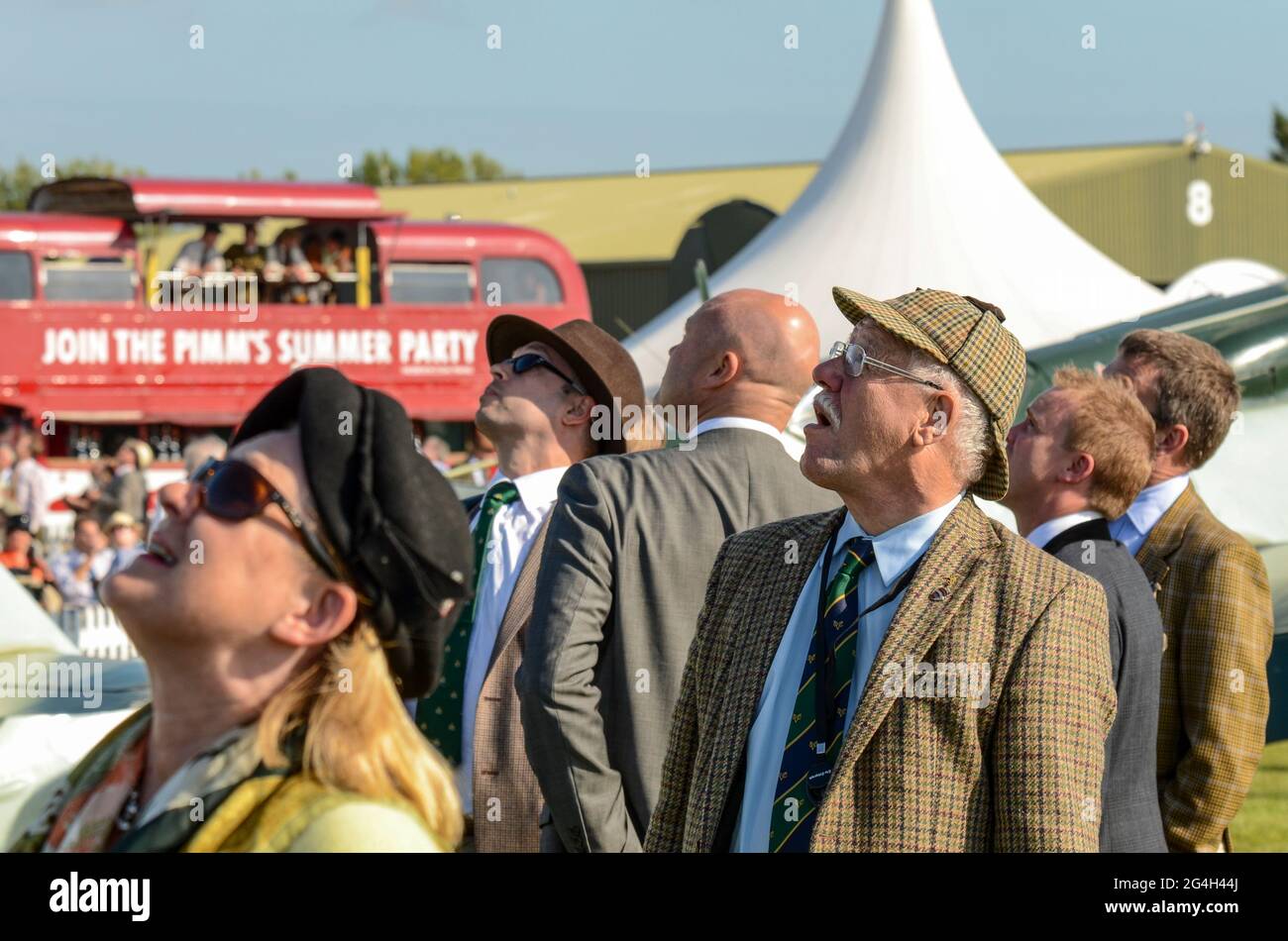 Visitatori in abbigliamento vintage guardando la mostra volante all'evento Goodwood Revival vintage, West Sussex, Regno Unito. Persone in costumi d'epoca Foto Stock