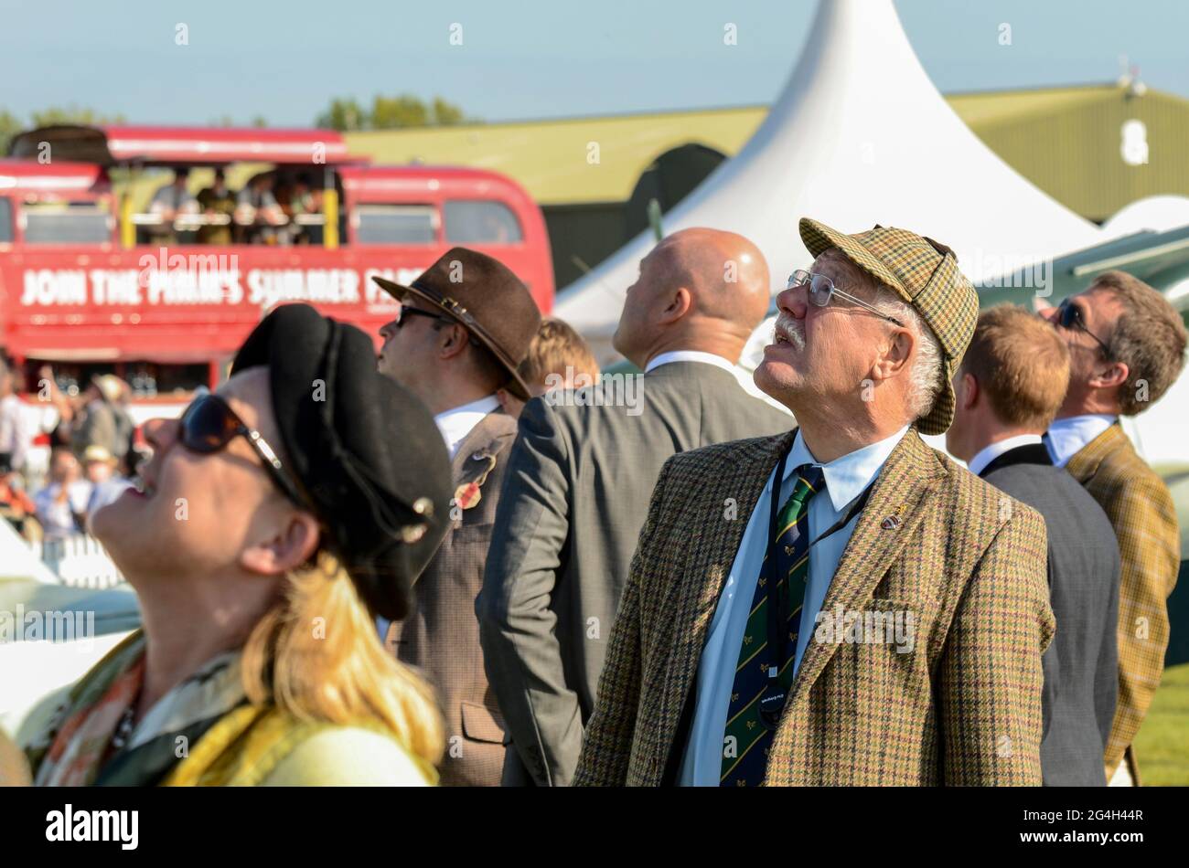 Visitatori in abbigliamento vintage guardando la mostra volante all'evento Goodwood Revival vintage, West Sussex, Regno Unito. Maschio in tweed vestiti Foto Stock