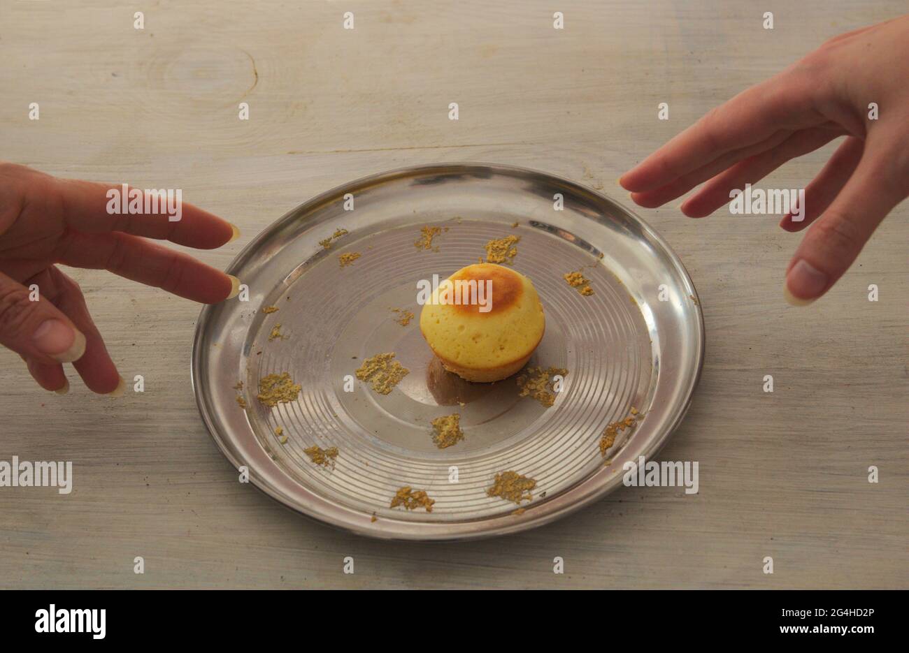 Su una piastra metallica un ultimo muffin. Da lati diversi delle due mani sono disegnate ad esso. Foto Stock