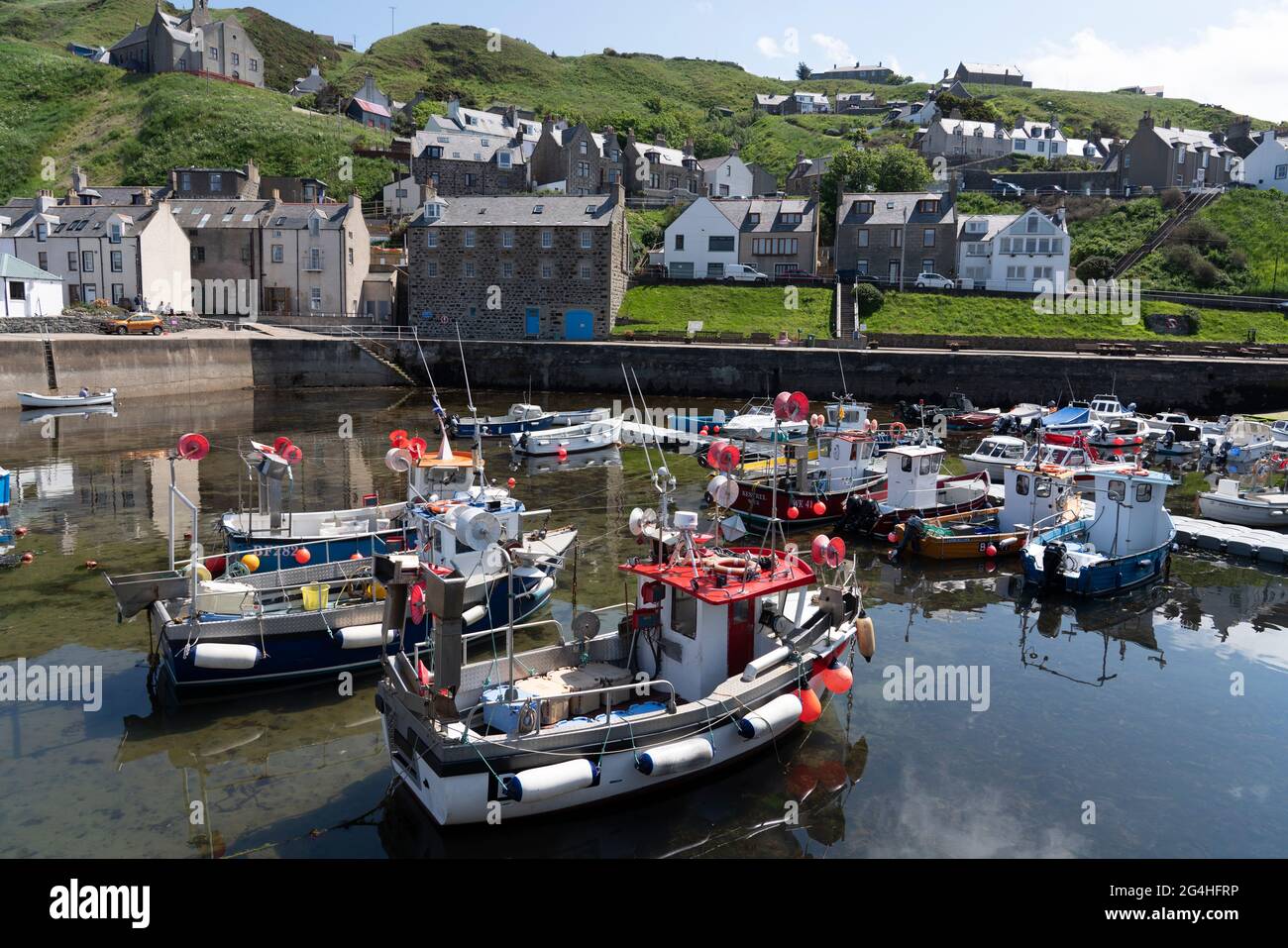 Ammira le barche da pesca nel porto dello storico villaggio di Gardenstown sulla Moray firth Coast ad Aberdeenshire, Scozia, Regno Unito Foto Stock