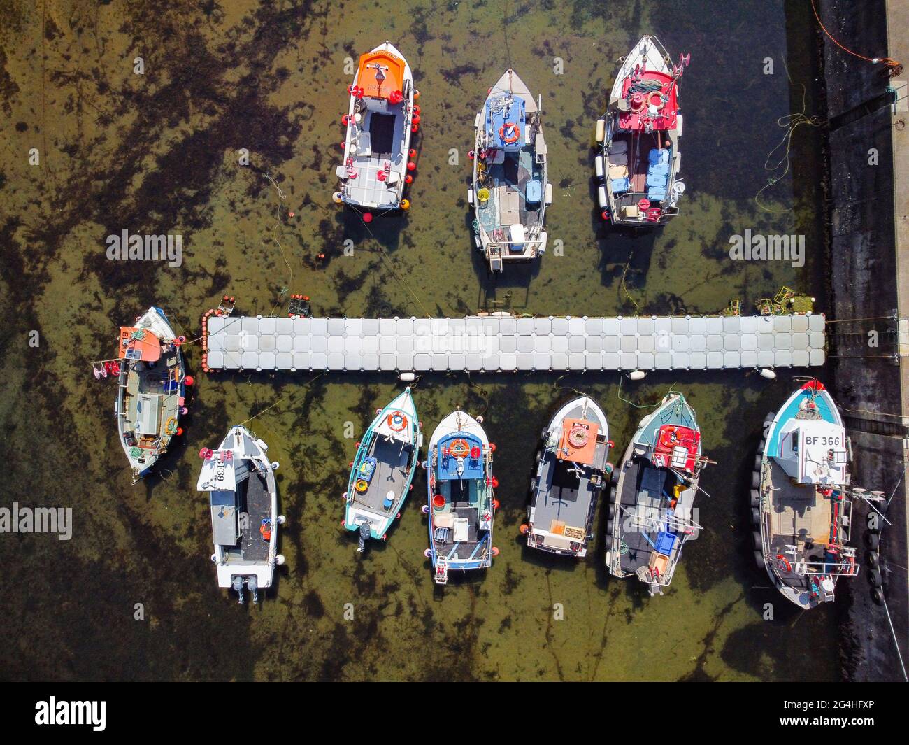 Vista aerea dal drone di barche da pesca nel porto presso il villaggio storico di Gardenstown sulla costa di Moray firth in Aberdeenshire, Scozia, Regno Unito Foto Stock