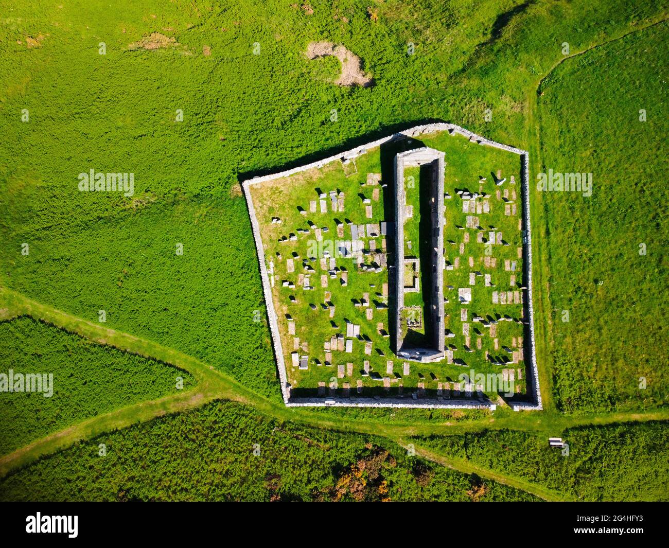 Vista aerea dal drone della chiesa di San Giovanni e Kirkyard che domina il villaggio di Gardenstown sulla costa di Moray firth ad Aberdeenshire, Scozia, Regno Unito Foto Stock