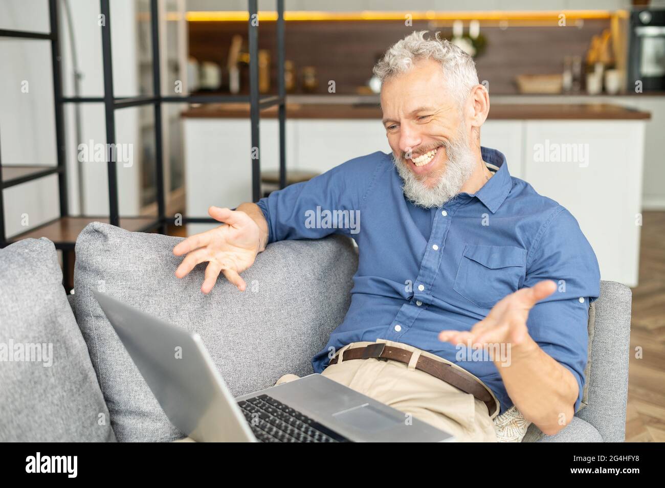 Felice uomo anziano sorridente che usa un computer portatile per la  connessione video, videochiama la famiglia o gli amici, maschio di mezza  età che guarda la webcam e parla con i gesti