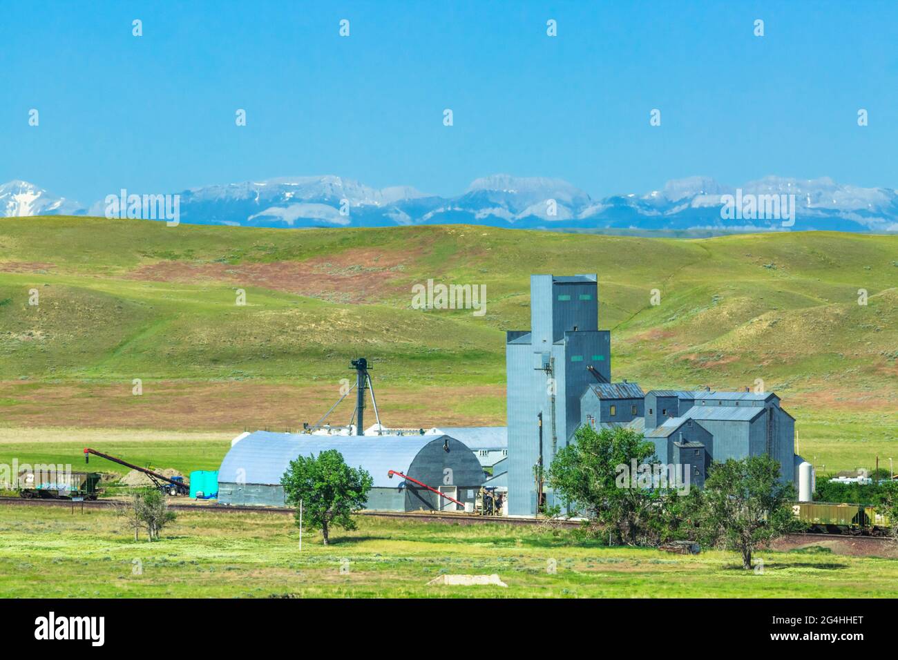 deposito di grano a ledger, montana, e cime distanti del fronte roccioso di montagna Foto Stock
