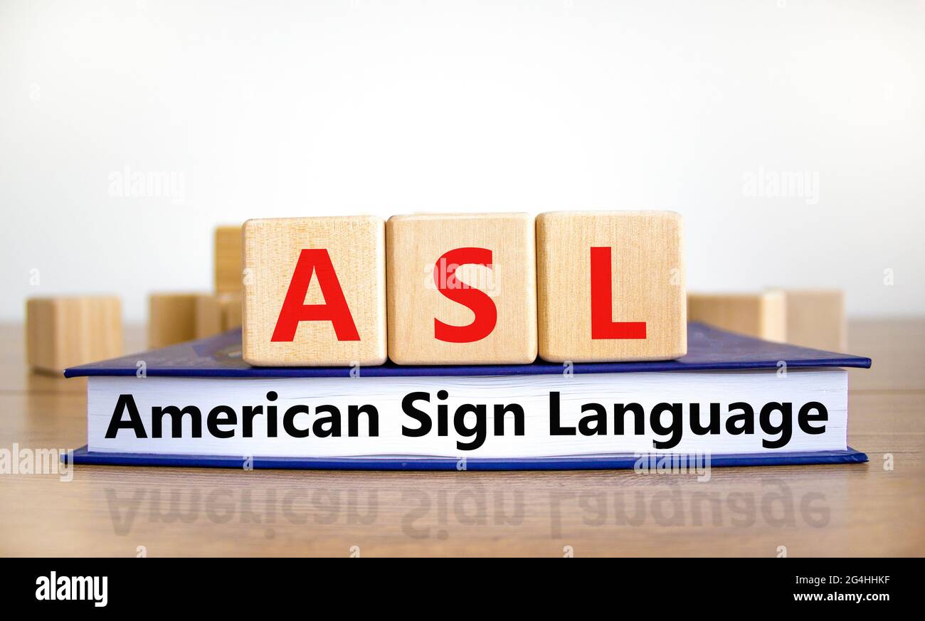 ASL, simbolo della lingua dei segni americana. Cubetti di legno su libro con le parole 'ASL, lingua americana dei segni'. Sfondo bianco. Medico e ASL, americano segno la Foto Stock