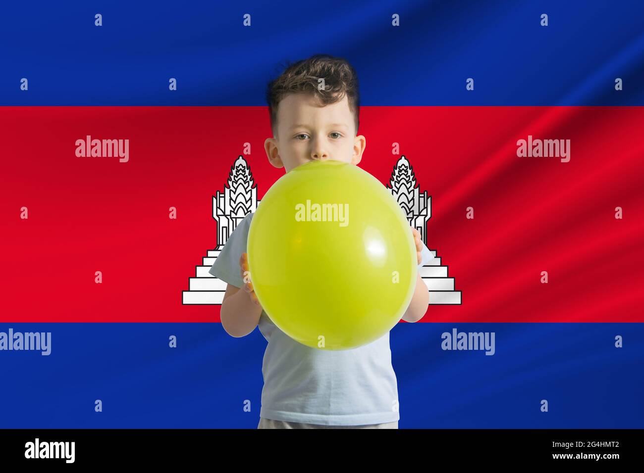 Giornata dei bambini in Cambogia ragazzo bianco con un pallone sullo sfondo della bandiera della Cambogia Festa dei bambini concetto. Foto Stock