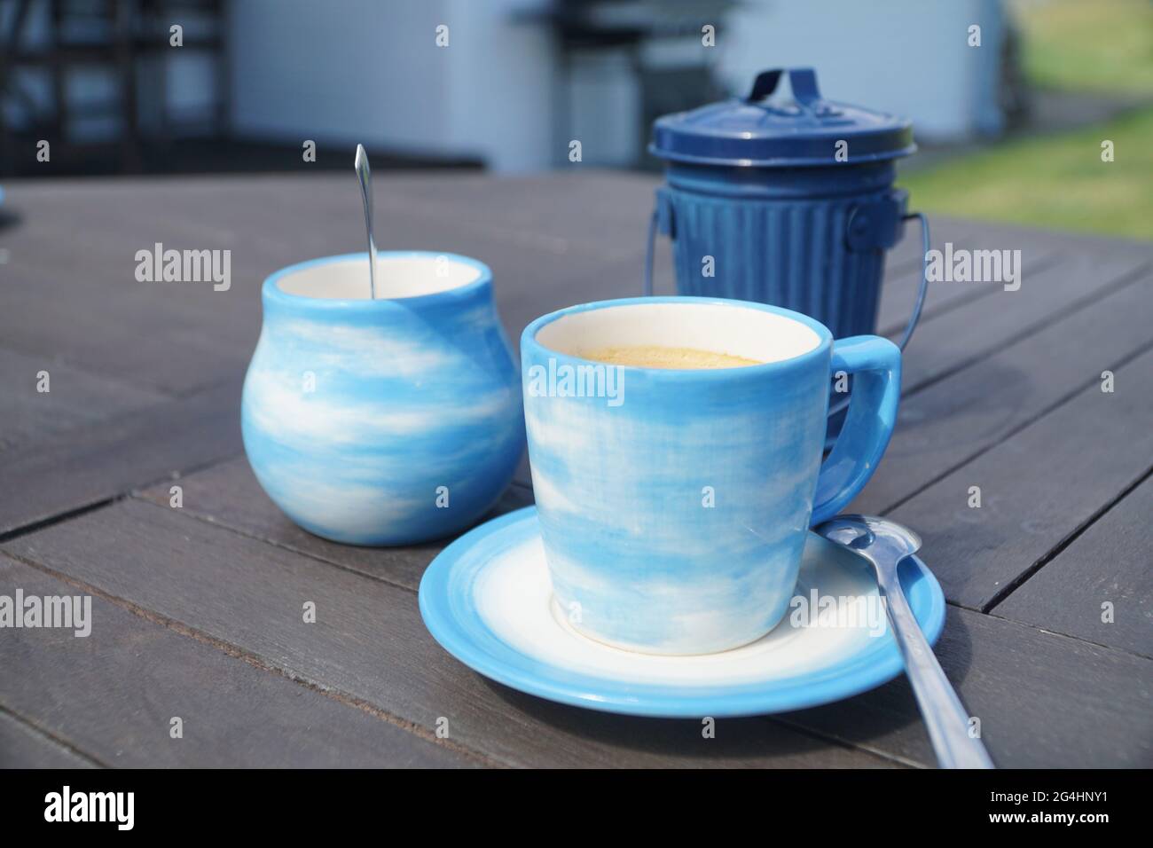Tazza di caffè del mattino su un tavolo di legno in una tazza blu. Foto Stock