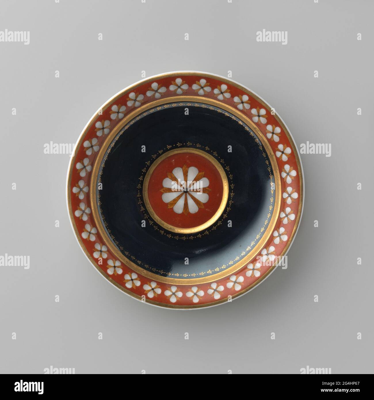 Piatto con pittura stilizzata in nero, rosso e oro. Piatto di porcellana, pittore policromo con bordo stilizzato con fiori e grande forma floreale sul piatto. Firma: Scettro con striscia; lettera P in oro. Con una testa corrispondente. Foto Stock