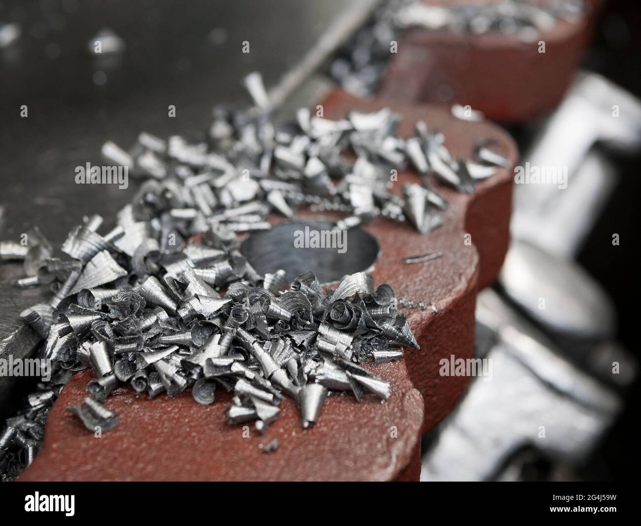 Trucioli di metallo sulla superficie del tornio, primo piano. Particelle metalliche tornate Foto Stock