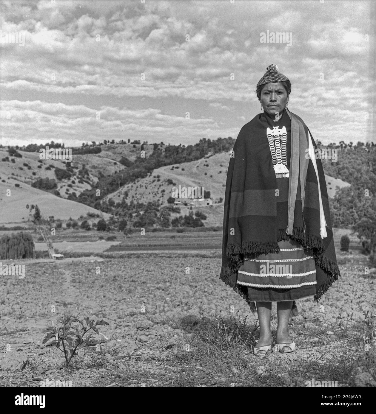 Giovane donna Mapuche con abito tradizionale sul lato del paese. Lumaco. Cile 1985 Foto Stock