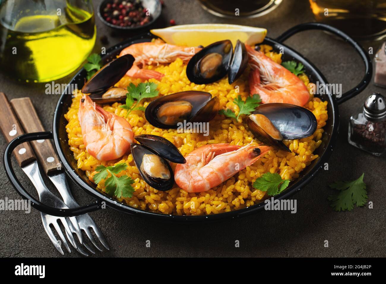 Paella spagnola tradizionale di pesce in padella con ceci, gamberetti,  cozze, calamari su fondo di cemento marrone Foto stock - Alamy