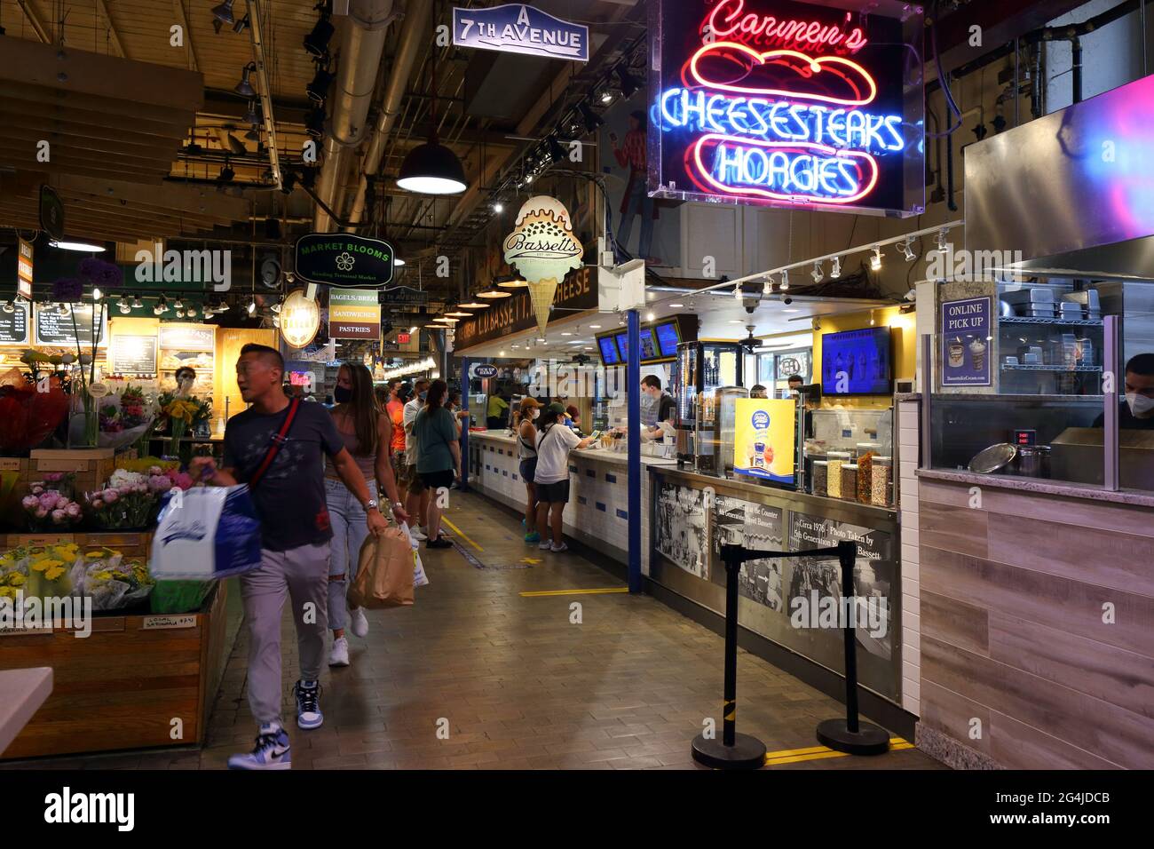 Persone che trasportano borse di omaggi dall'interno del Reading Terminal Market, Philadelphia, Pennsylvania. Foto Stock