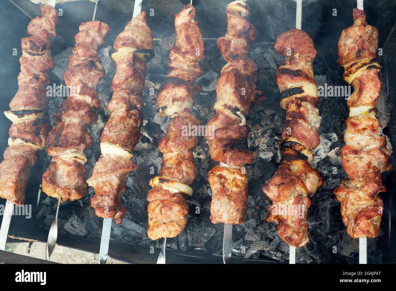 Marinata di spiedini preparazione su un grill barbecue a carbone. Spiedini o shish kebab popolare in Europa orientale. Shashlyk (spiedini di carne) era origine Foto Stock