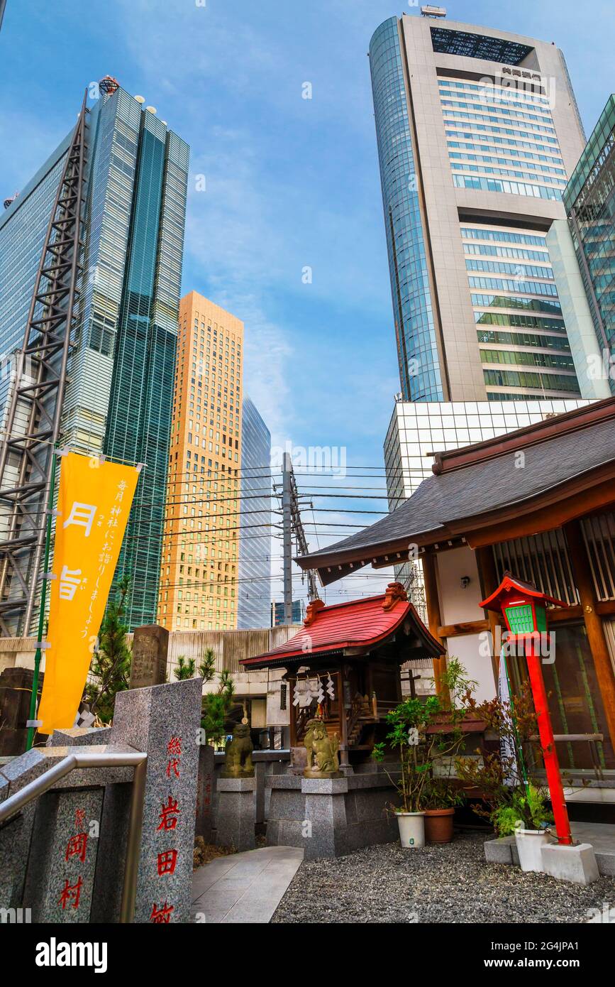Tradizione e modernità in Giappone. Vista di Shimbashi-Shiodome moderni grattacieli dietro la porta rossa di Hibiya Santuario nel centro cittadino Foto Stock