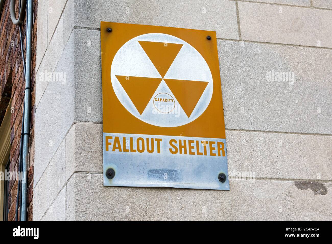 Il cartello Fallout Shelter informa sullo spazio chiuso vicino appositamente progettato per proteggere gli occupanti da detriti radioattivi o da eventuali ricadute derivanti da un Foto Stock