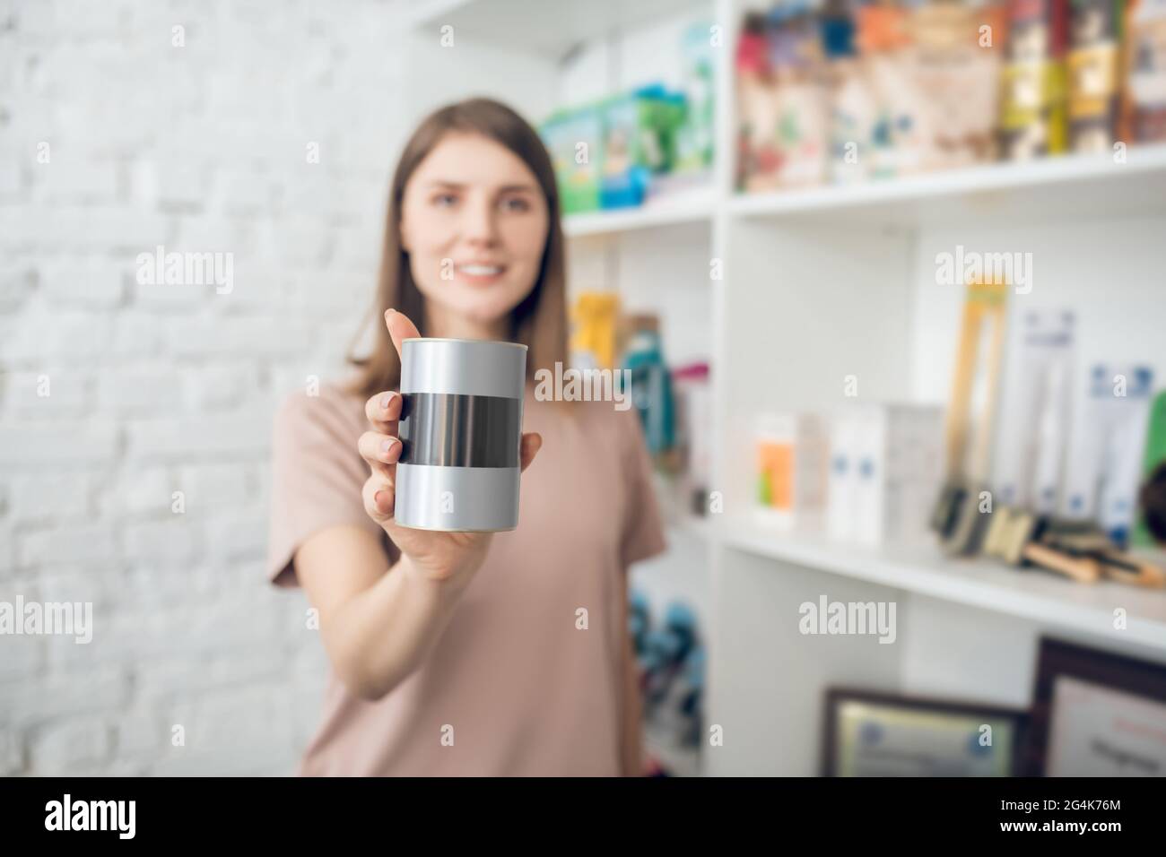 Ragazza dai capelli scuri che sceglie gli accessori per l'animale domestico in un deposito dell'animale domestico Foto Stock