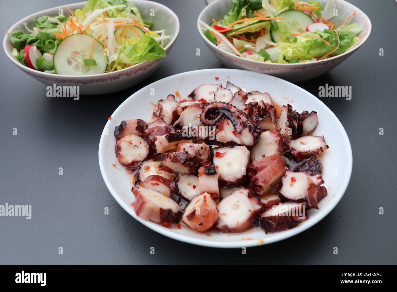 tentacoli piccanti di polpo serviti con un'insalata Foto Stock