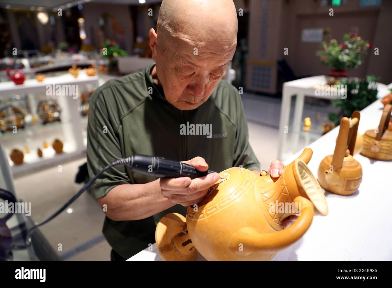 22 giugno 2021, Cina: Il 20 giugno, Luo Baocai ha fatto gourd artigianato al Grande Bazaar intangibile Beni culturali Museo di Erdaoqiao, Urumqi. Un saldatore o alcuni coltelli da intaglio, semplici attrezzi messi nelle mani di Wang Guowei, possono trasformare una zucca liscia in un artigianato squisito. Luo Baocai, che è nei suoi anni '70, vive nella casa di famiglia della Wangjialiang Bus Company a Urumqi. Dopo essere andato in pensione nel 2000, ha cominciato a coltivare i gourds e a fare i mestieri gourd a casa. Dopo anni di duro lavoro, i mestieri gourd che ha prodotto hanno linee lisce e modelli vividi. Formare un settore. (Immagine di credito: © SIPA Asia via Z Foto Stock