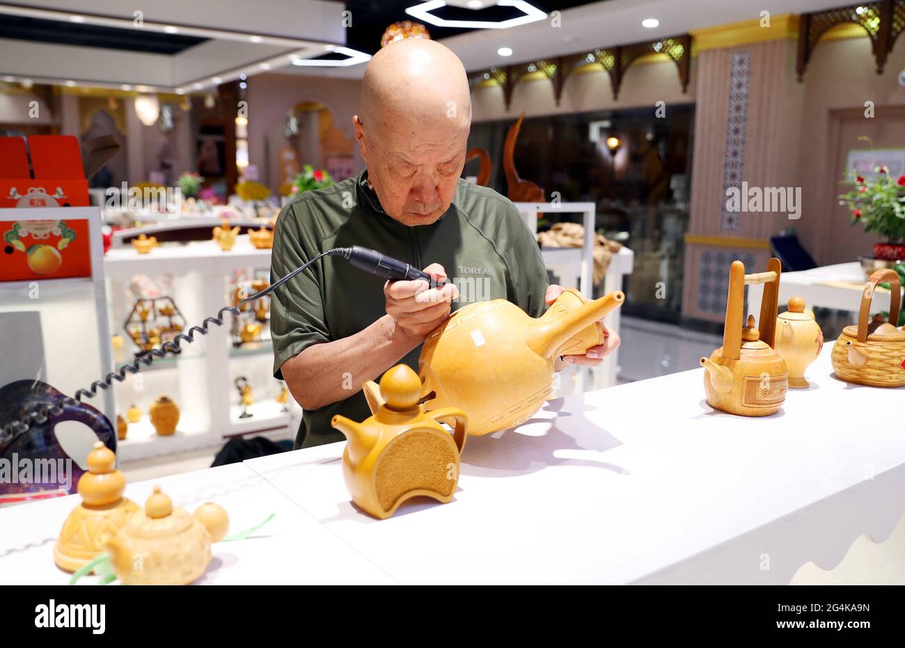 22 giugno 2021, Cina: Il 20 giugno, Luo Baocai ha fatto gourd artigianato al Grande Bazaar intangibile Beni culturali Museo di Erdaoqiao, Urumqi. Un saldatore o alcuni coltelli da intaglio, semplici attrezzi messi nelle mani di Wang Guowei, possono trasformare una zucca liscia in un artigianato squisito. Luo Baocai, che è nei suoi anni '70, vive nella casa di famiglia della Wangjialiang Bus Company a Urumqi. Dopo essere andato in pensione nel 2000, ha cominciato a coltivare i gourds e a fare i mestieri gourd a casa. Dopo anni di duro lavoro, i mestieri gourd che ha prodotto hanno linee lisce e modelli vividi. Formare un settore. (Immagine di credito: © SIPA Asia via Z Foto Stock