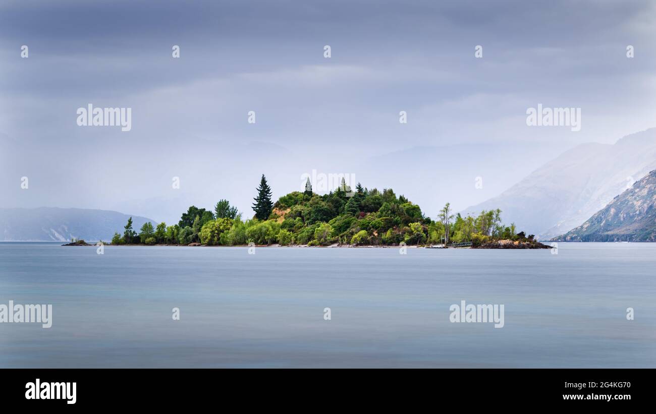 Isola Ruby sul lago Wanaka con montagne di sfondo nella nebbia, Otago Regione, Isola del Sud Foto Stock