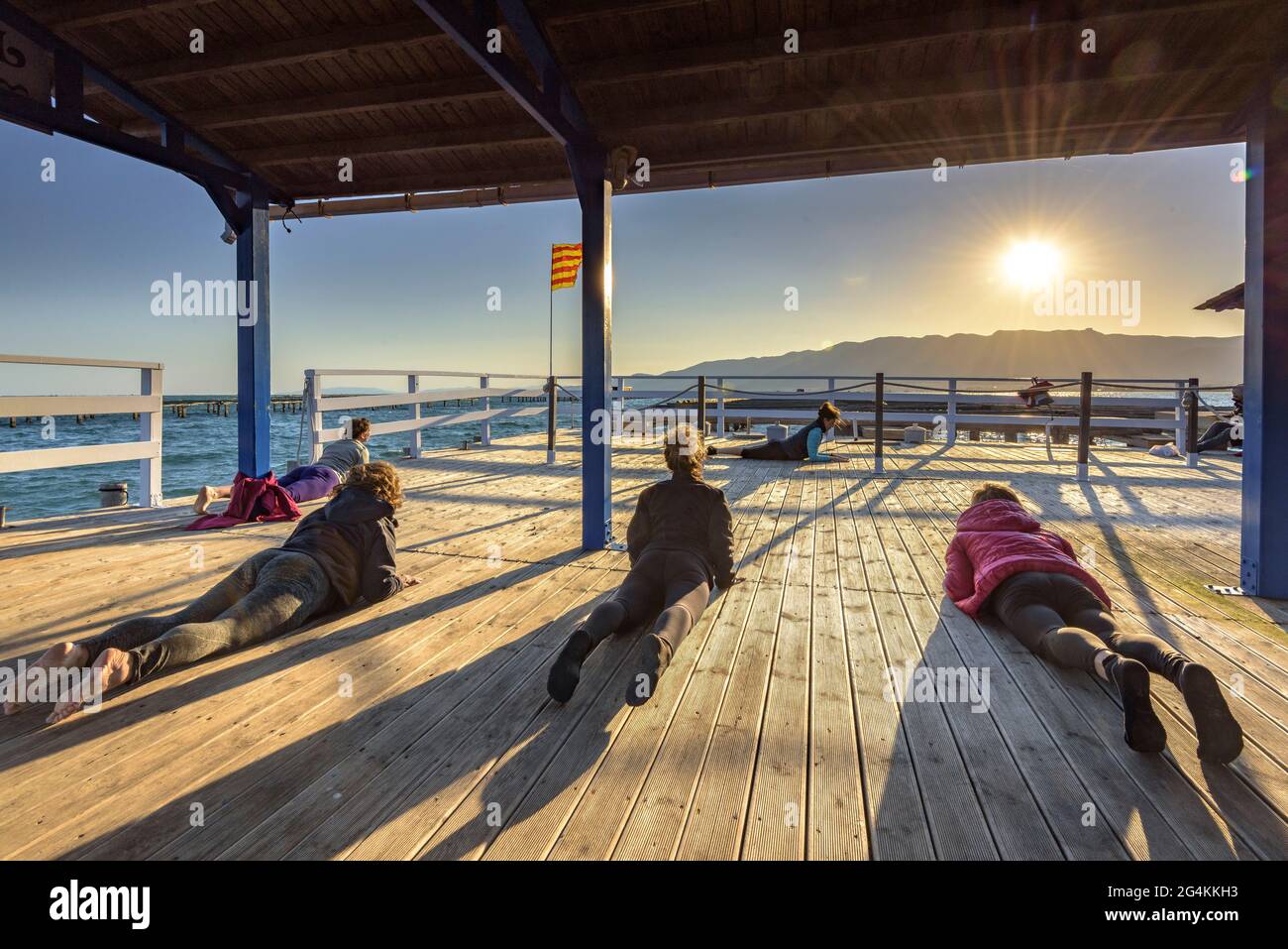 Donne che praticando yoga in una fattoria di cozze nella baia di Alfacs nel delta dell'Ebro (Tarragona, Catalogna, Spagna) ESP: Participantes en actividad de yoga (España) Foto Stock