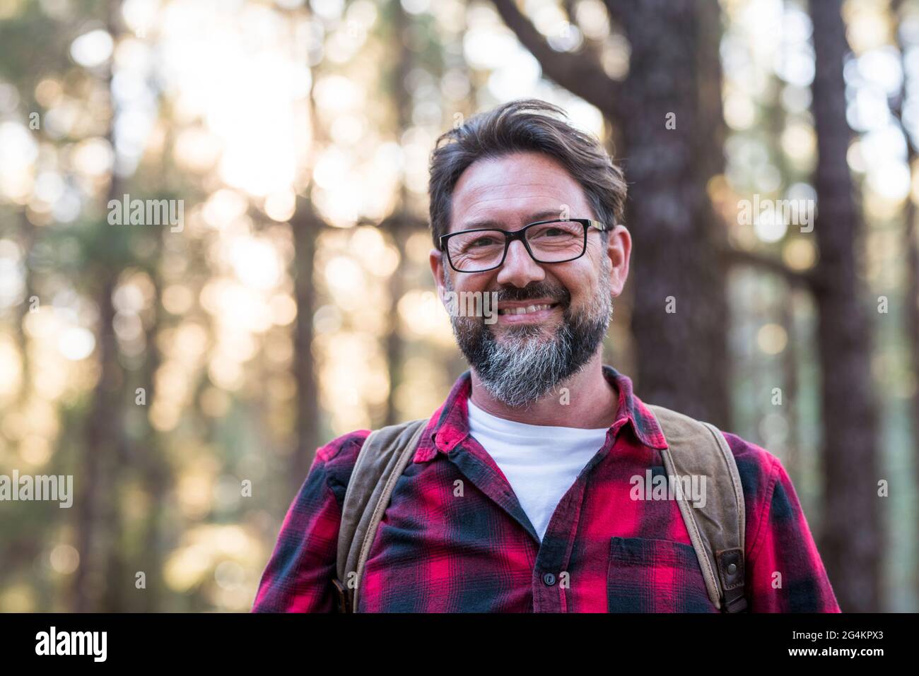 Ritratto di un uomo escursionista che cammina sul sentiero nel bosco. Felice stile di vita uomo in viaggio con zaino su uno sfondo di foresta - godendo di ambiente Foto Stock