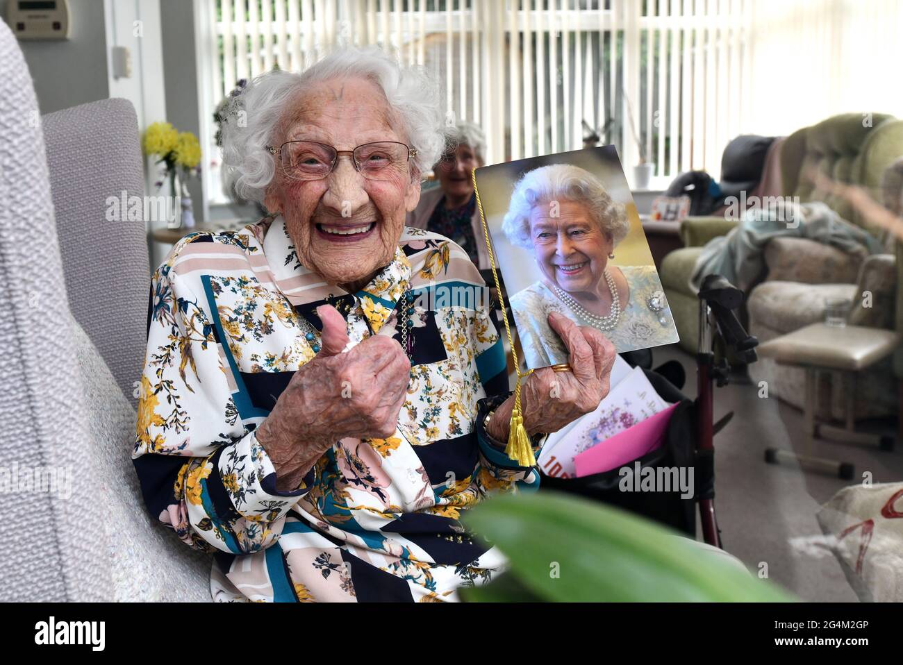 Care home residente celebrare il suo 100th compleanno con una carta della Regina durante la pandemia di Covid. Centenarian 100 anni Foto Stock