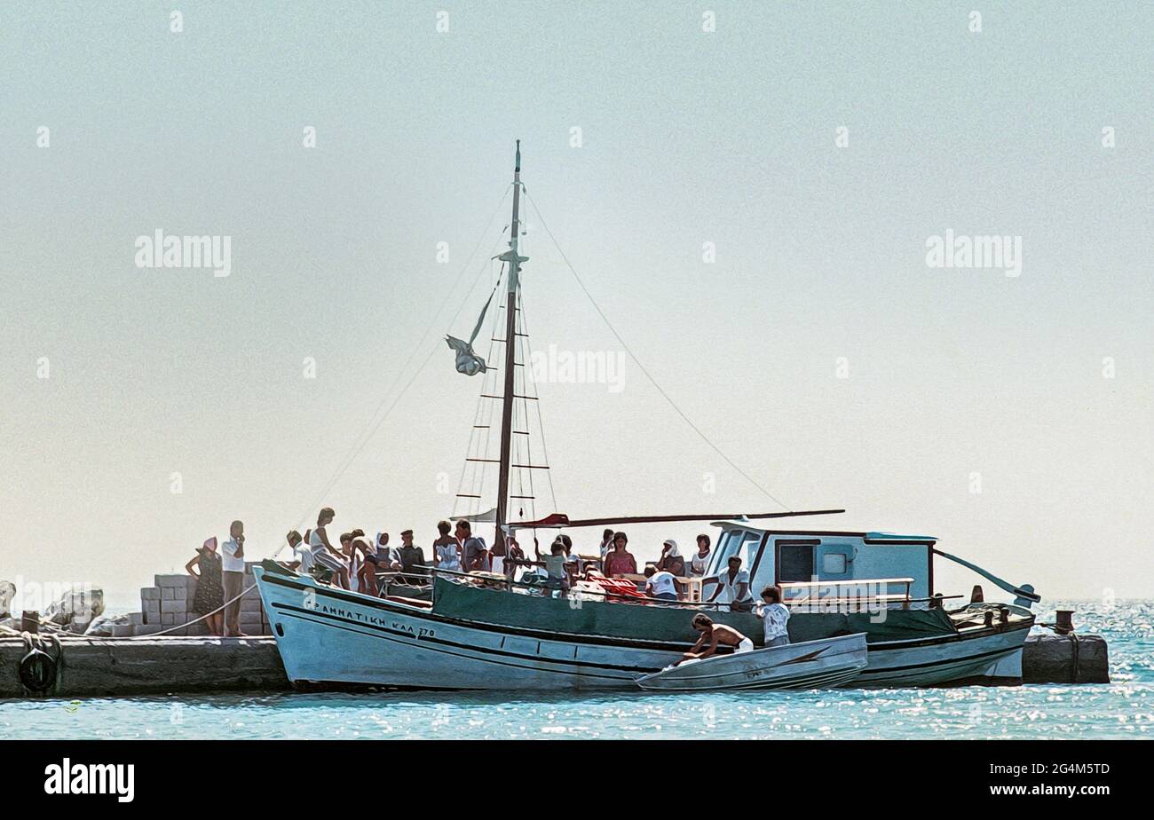 Immagine scansionata di una barca che arriva al porto nella piccola isola di Pserimos, al largo di Kos, il locale schierarsi per acquistare le loro disposizioni circa 1984 a ph Foto Stock