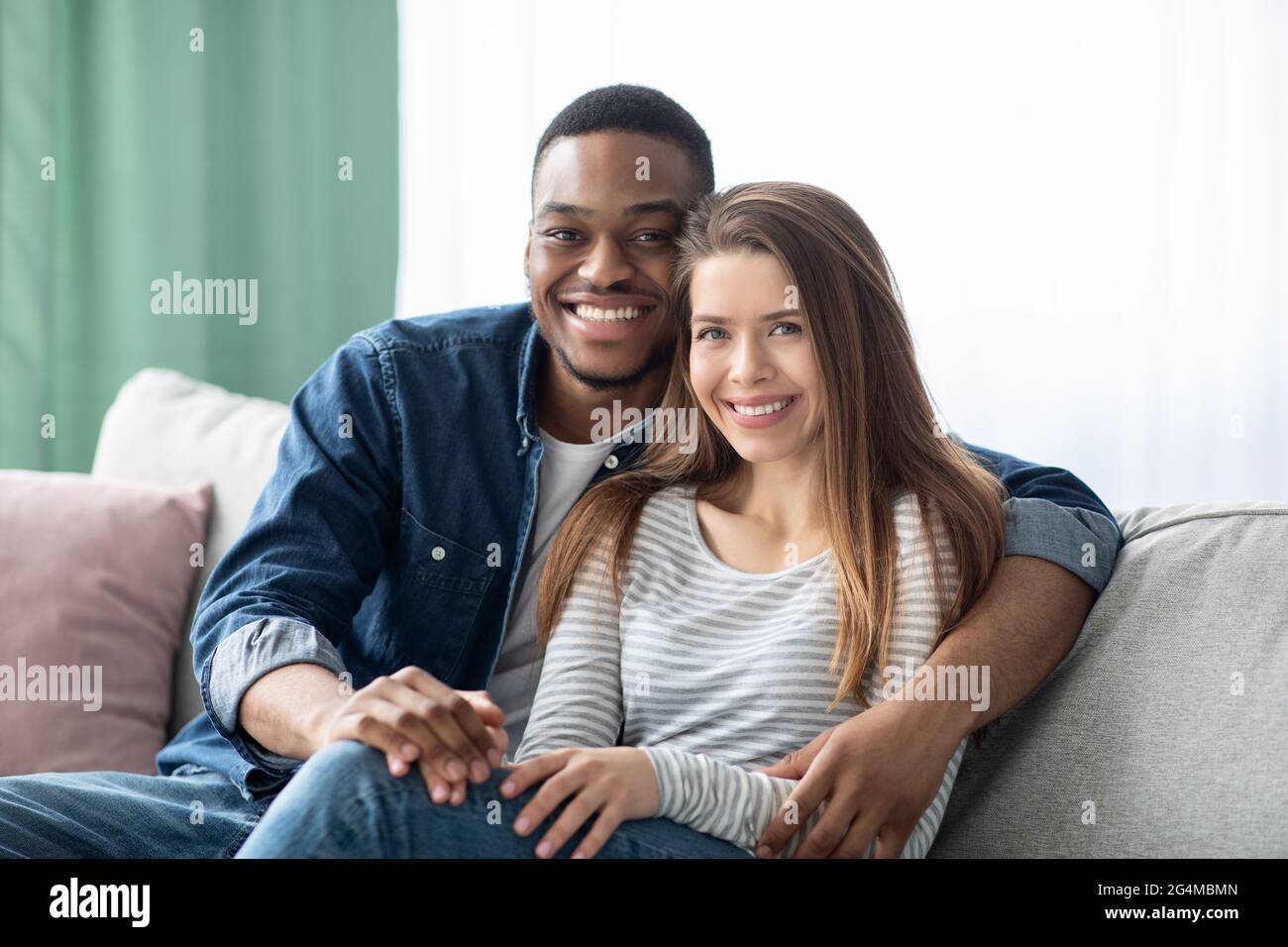 Ritratto di giovane giovane coppia multiculturale sorridente che posa in Home Interior Foto Stock