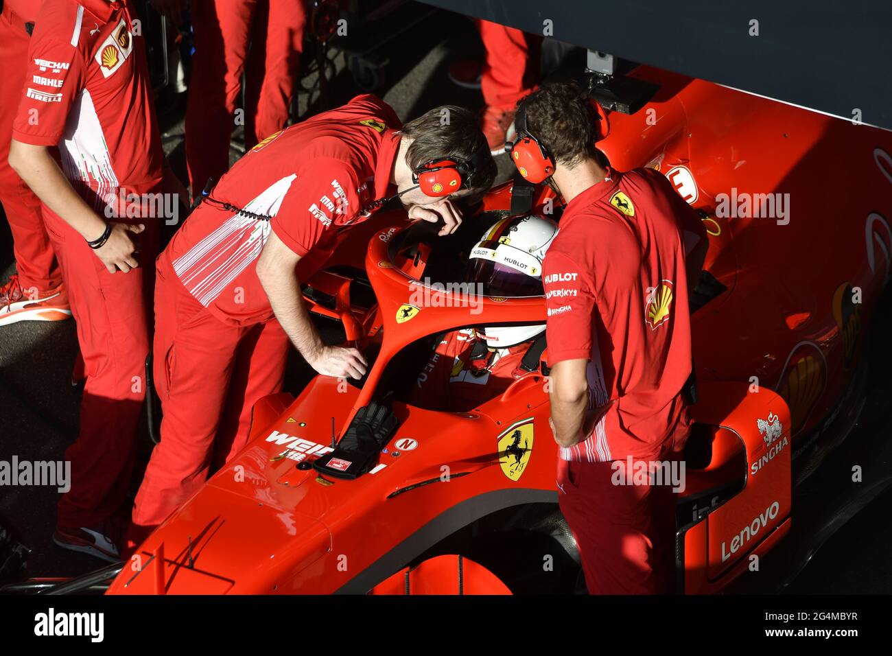 L'equipaggio dei box Ferrari lavora intorno alla Ferrari Formula uno al box Ferrari, durante una mostra a Milano. Foto Stock