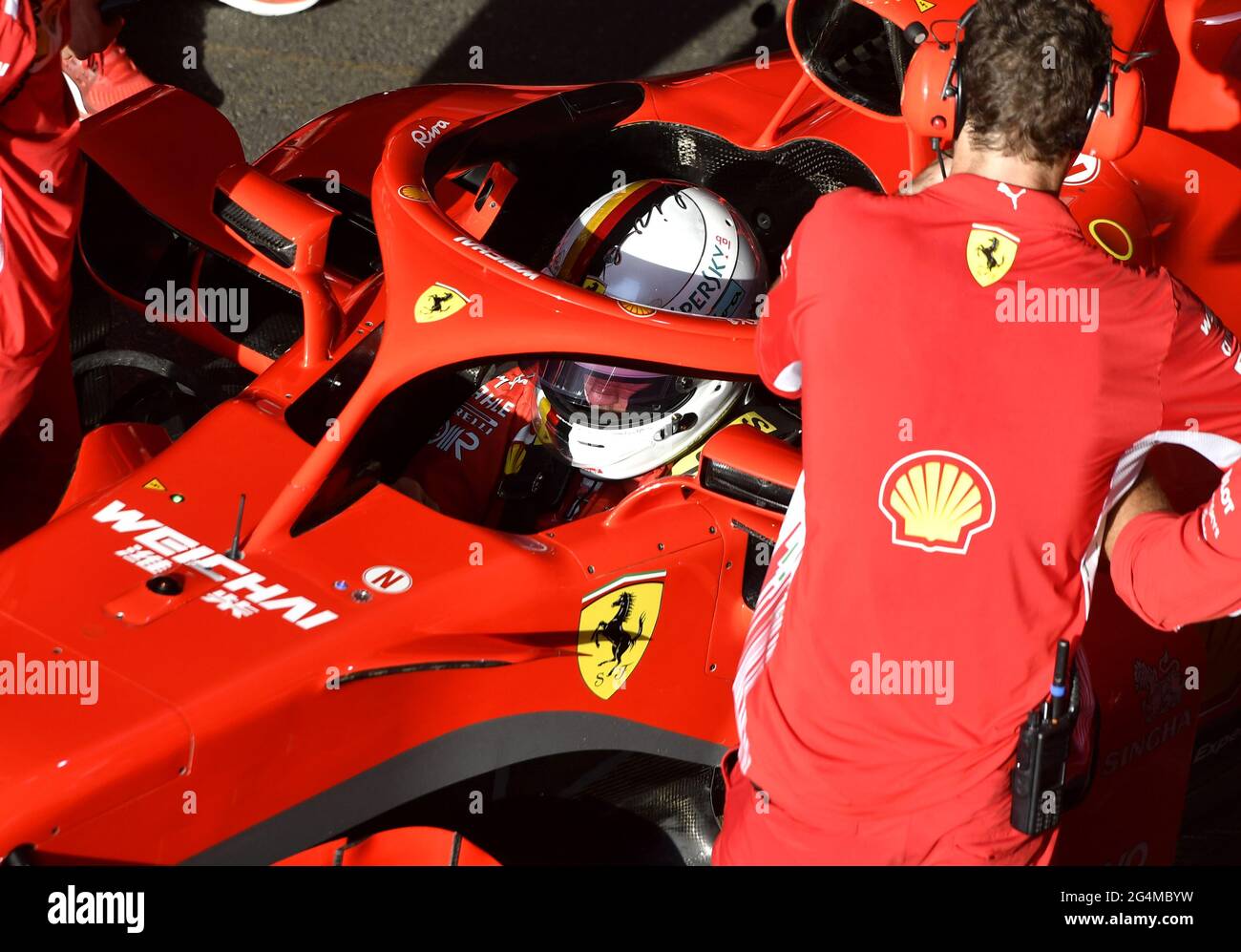 L'equipaggio dei box Ferrari lavora intorno alla Ferrari Formula uno al box Ferrari, durante una mostra a Milano. Foto Stock