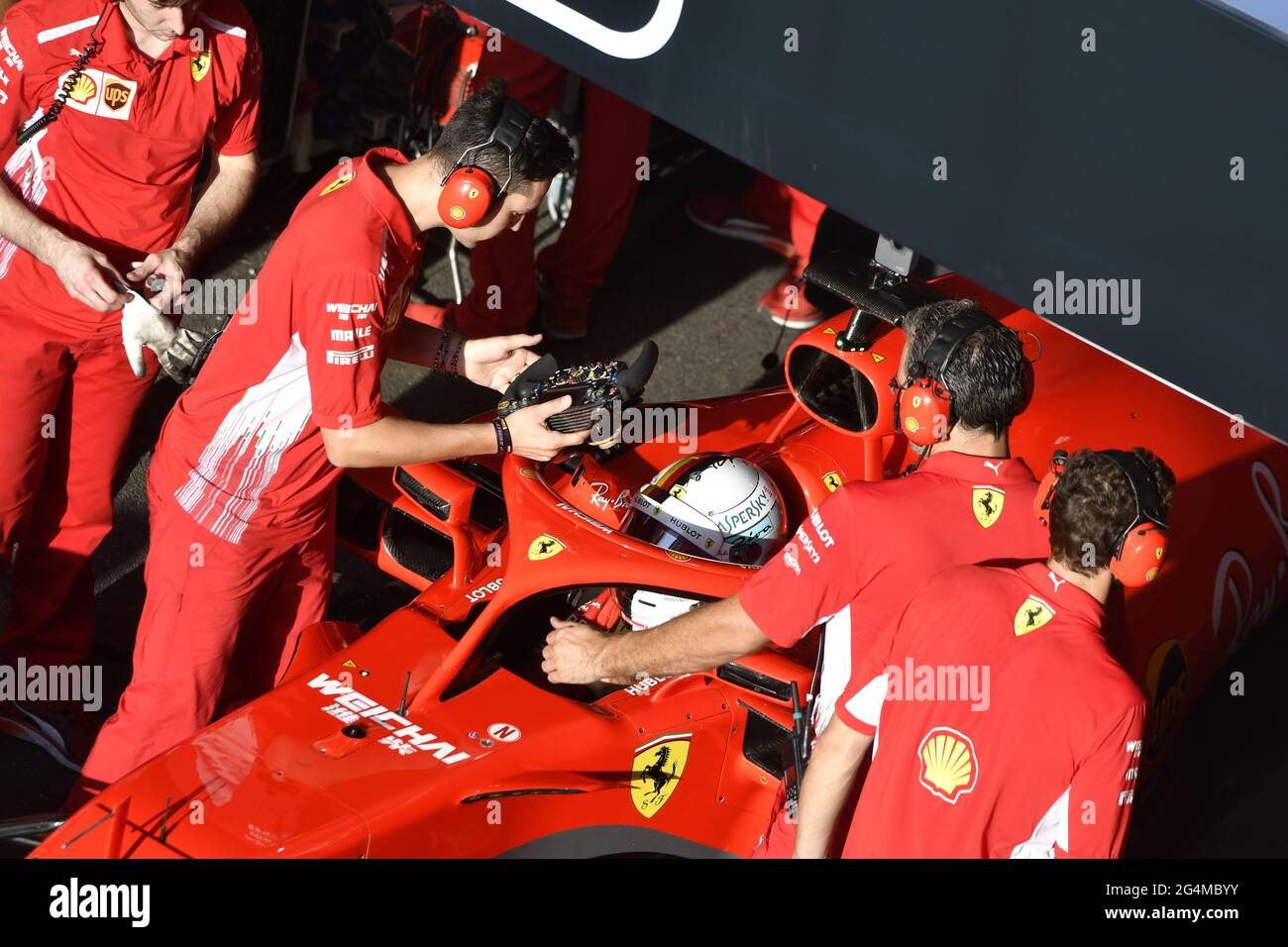 L'equipaggio dei box Ferrari lavora intorno alla Ferrari Formula uno al box Ferrari, durante una mostra a Milano. Foto Stock