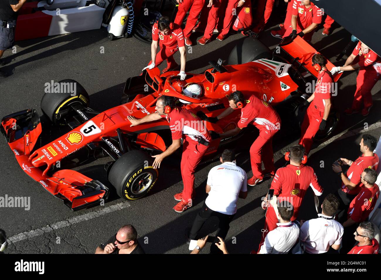 L'equipaggio dei box Ferrari lavora intorno alla Ferrari Formula uno al box Ferrari, durante una mostra a Milano. Foto Stock