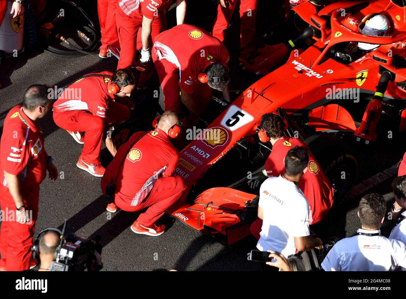 L'equipaggio dei box Ferrari lavora intorno alla Ferrari Formula uno al box Ferrari, durante una mostra a Milano. Foto Stock