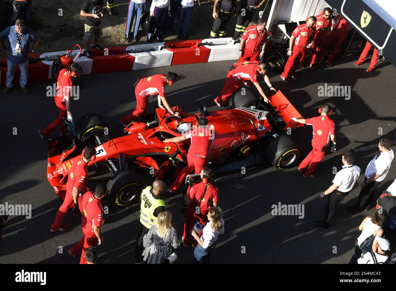 L'equipaggio dei box Ferrari lavora intorno alla Ferrari Formula uno al box Ferrari, durante una mostra a Milano. Foto Stock