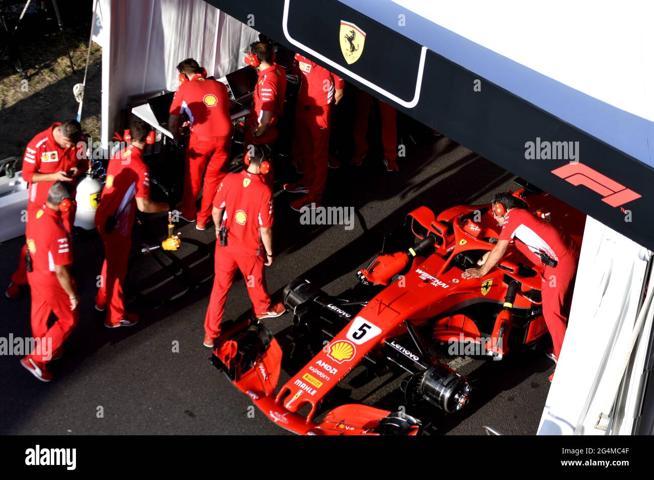 L'equipaggio dei box Ferrari lavora intorno alla Ferrari Formula uno al box Ferrari, durante una mostra a Milano. Foto Stock