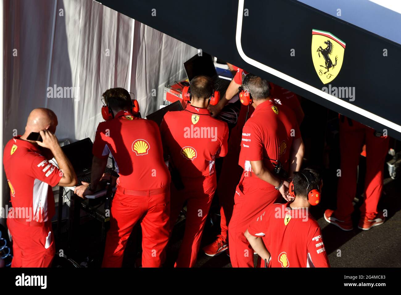 L'equipaggio dei box Ferrari lavora intorno alla Ferrari Formula uno al box Ferrari, durante una mostra a Milano. Foto Stock