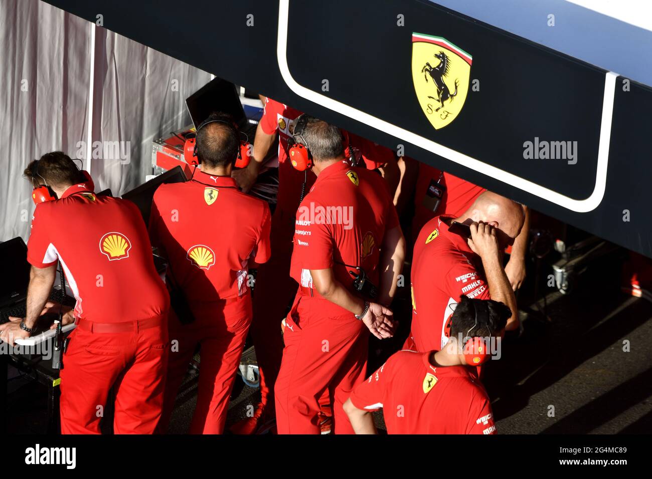 L'equipaggio dei box Ferrari lavora intorno alla Ferrari Formula uno al box Ferrari, durante una mostra a Milano. Foto Stock