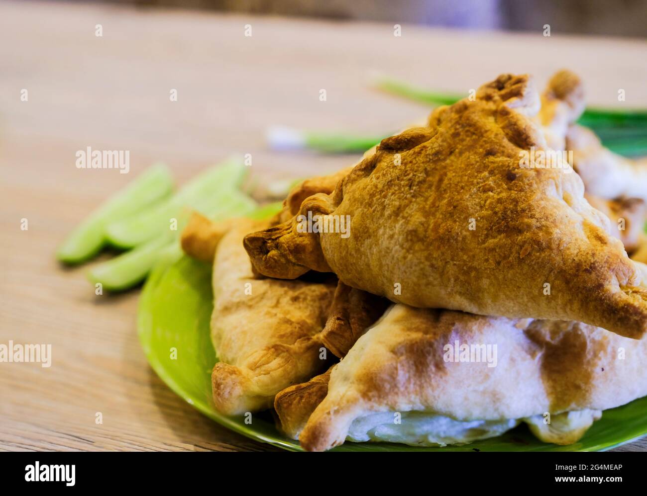 Si tratta di una vera e propria samsa uzbeka su un piatto con verdure e cipolle verdi. Cucina nazionale Foto Stock