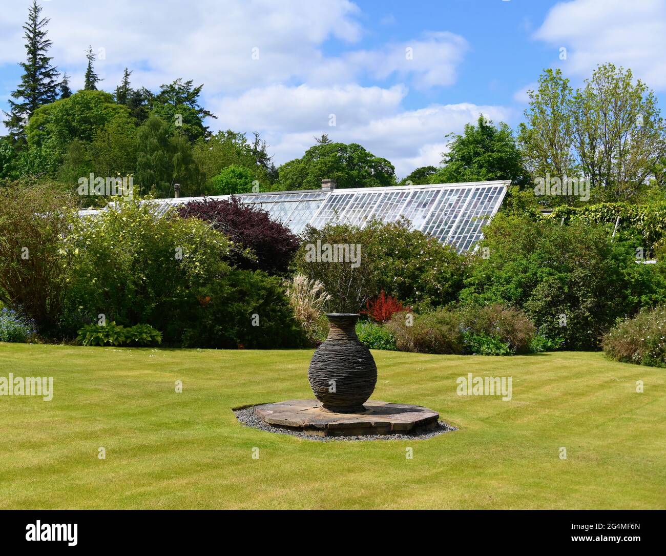 Il Mackenzie & Montur Glasshouse e la scultura all'aperto di James Parker nel giardino murato. Giardini Kailzie. Kilburn, Scottish Borders, Regno Unito Foto Stock