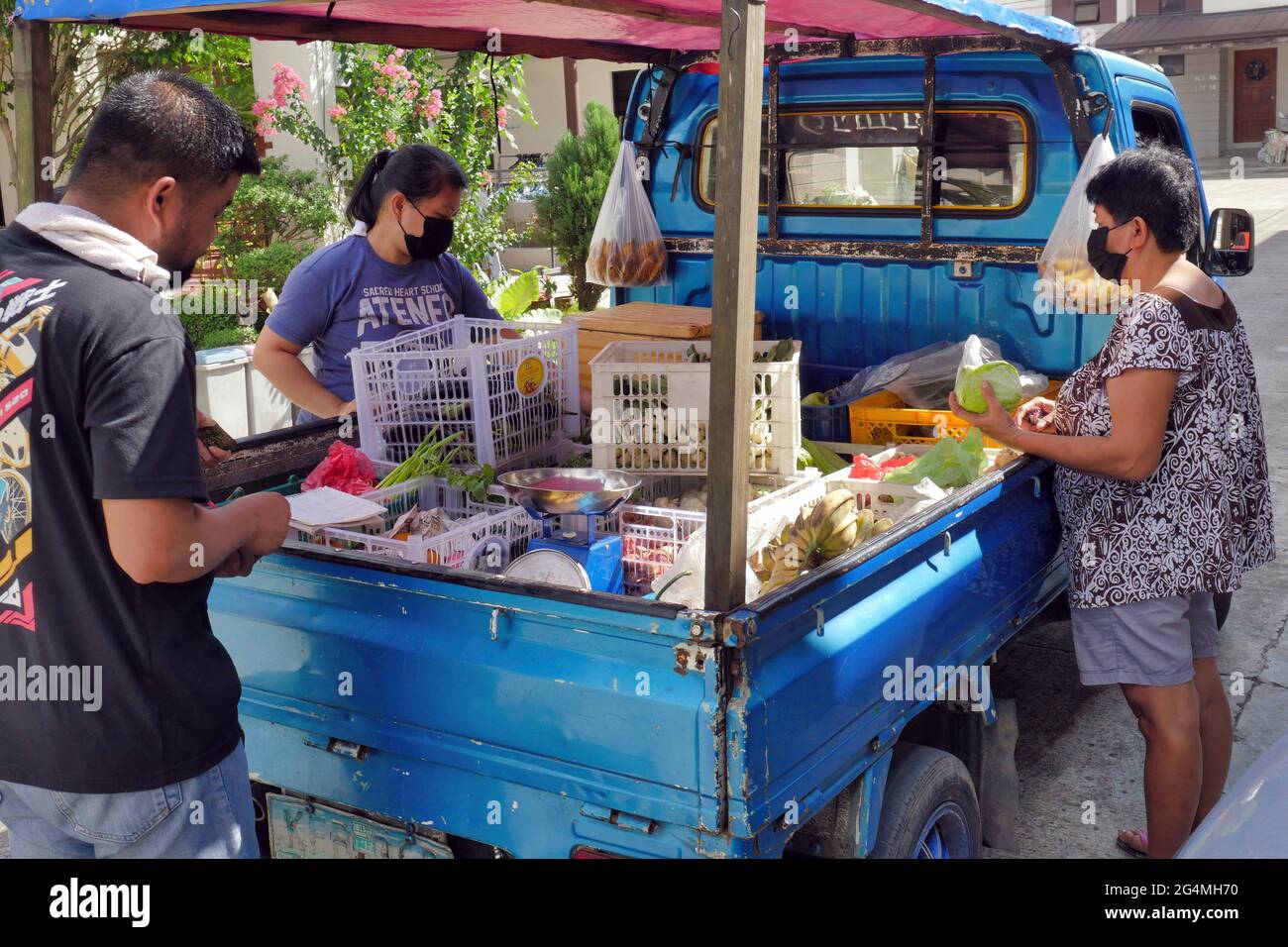 Cebu City, Filippine; 21 giugno 2021 -- residenti della sottodivisione durante la pandemia che acquistano frutta e verdura da un venditore ambulante sul suo veicolo. Foto Stock