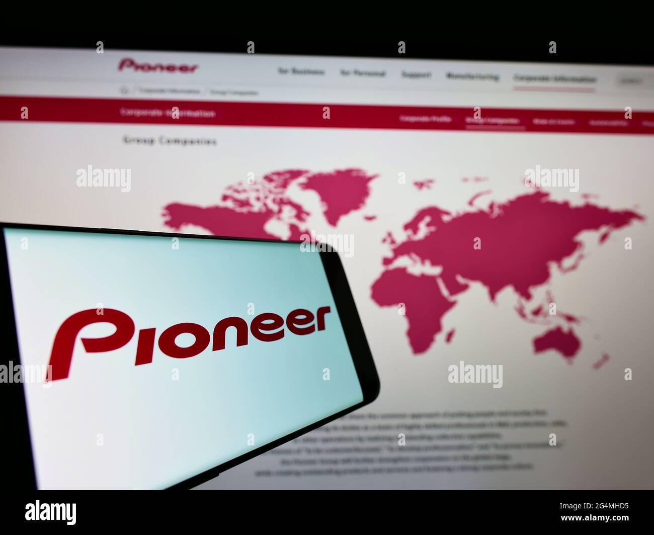 Smartphone con logo della società elettronica giapponese Pioneer K.K. sullo schermo di fronte al sito Web aziendale. Mettere a fuoco il centro-destra del display del telefono. Foto Stock