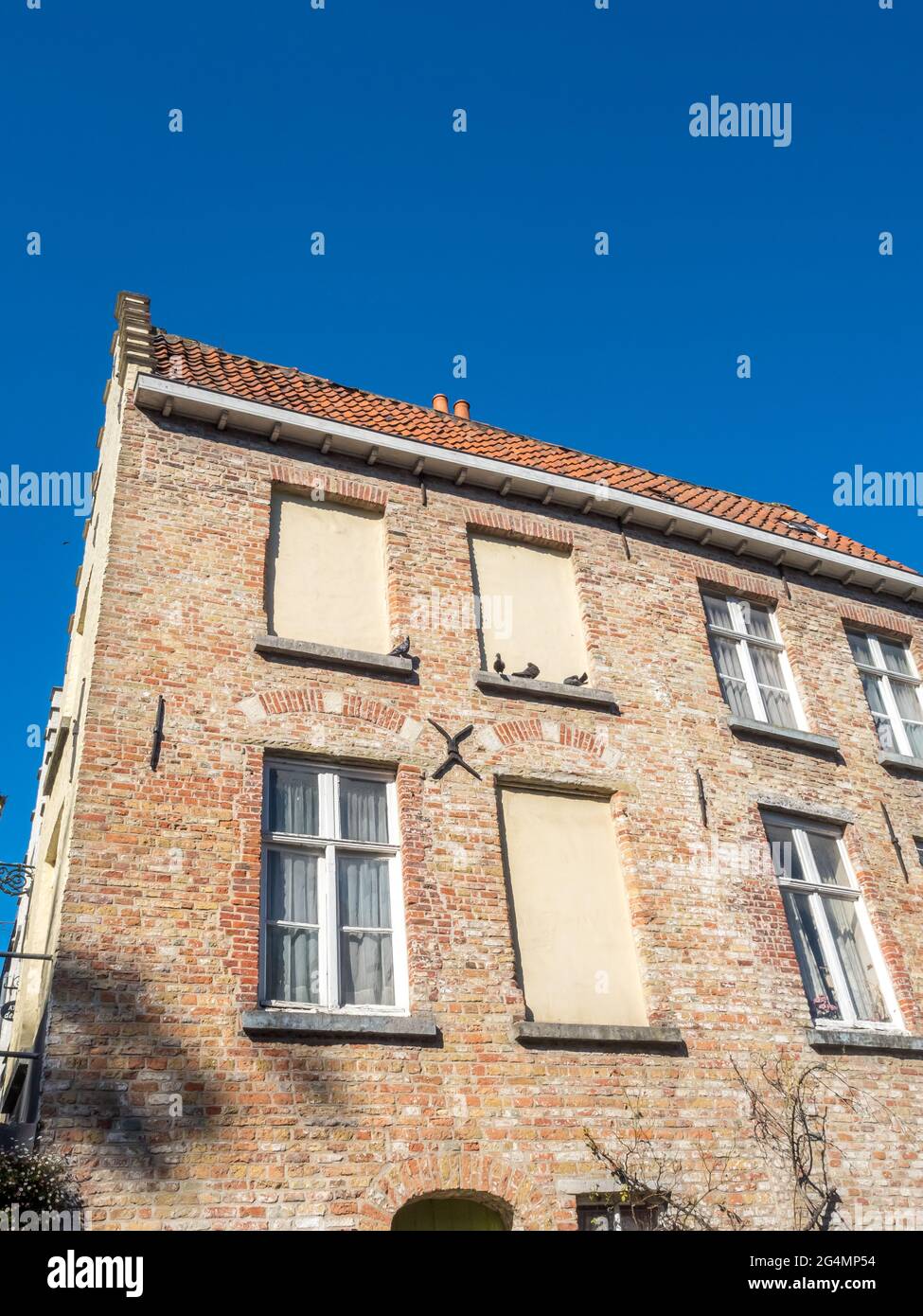 Brugge scene della città in Belgio, edifici residenziali attraenti e belle scene lungo il canale crusante, sotto il cielo blu Foto Stock