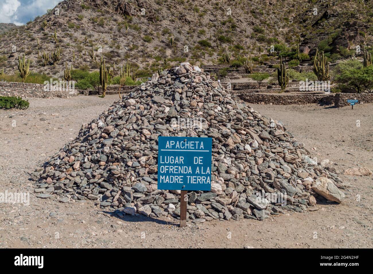 Mucchio di pietre a Quilmes rovine, Argentina. Il testo sul segno dice: Luogo dell'offerta per la madre terra. Foto Stock