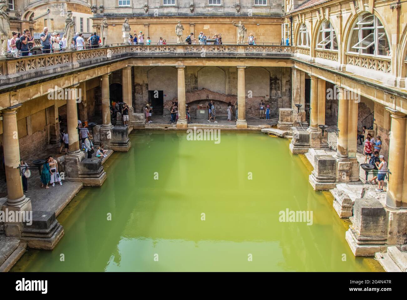 7 25 2019Bath UK antichi bagni romani con acqua molto verde in giornata di sole - vista dall'alto con i turisti su due livelli - la maggior parte su telefoni o prendendo foto Foto Stock