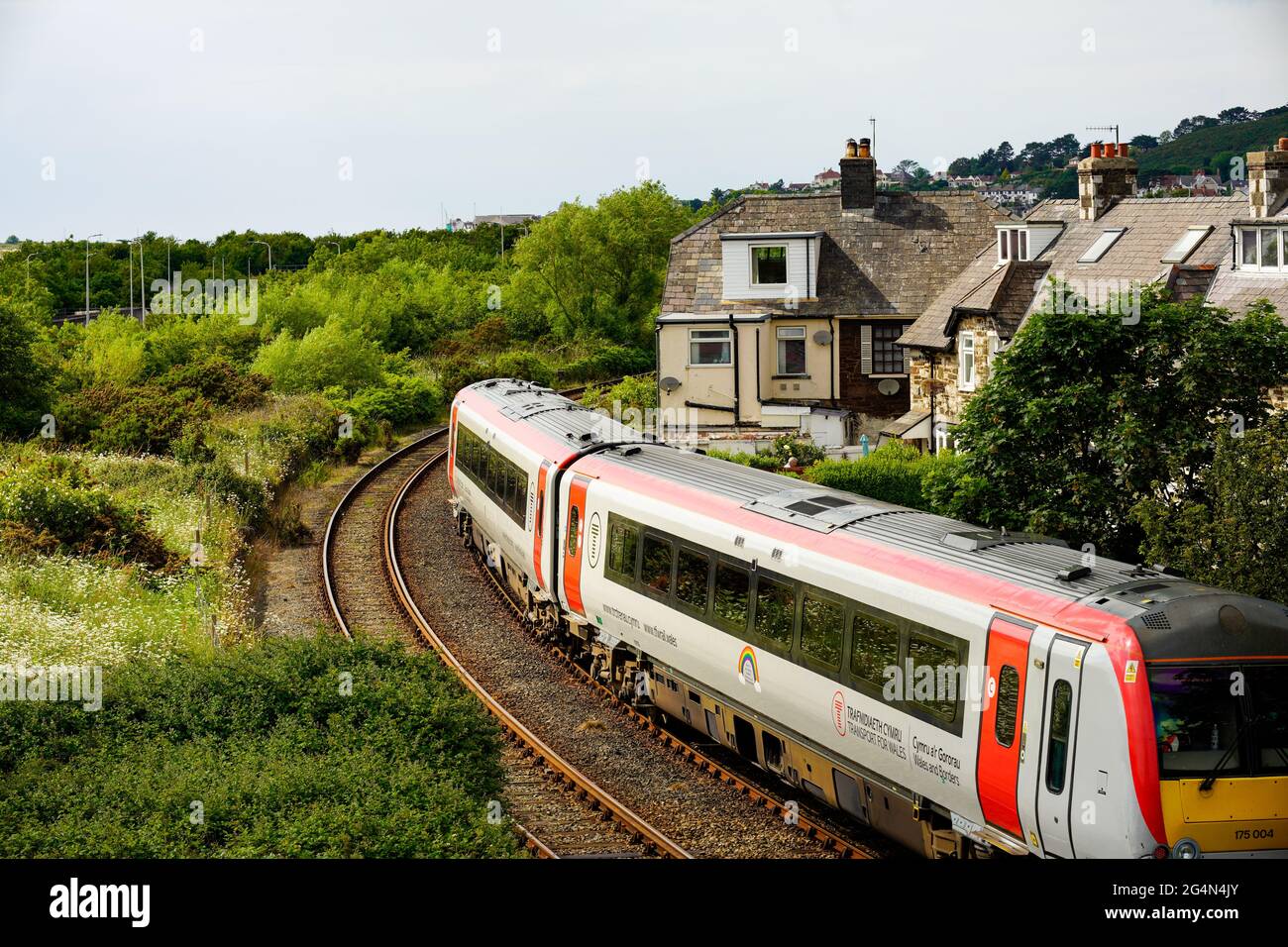 Il treno diesel viaggia ad angolo vicino alle case domestiche Foto Stock
